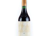 a bottle of red wine sitting on top of a white table