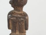 a small wooden statue of a man sitting on a stool