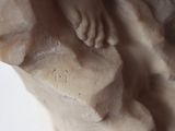 a close up of a statue of a woman with her hands on her chest