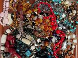 un plateau en bois rempli d'un assortiment de perles et de colliers