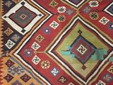 an image of a red and blue rug on a wooden floor