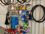 many bikes hanging on the wall in this garage