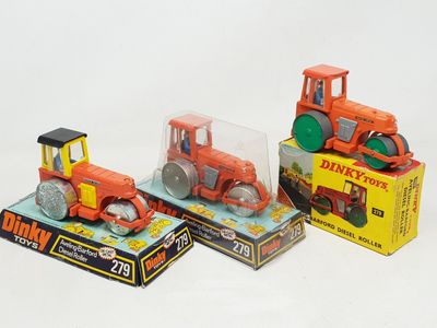 trois tracteurs miniatures exposés dans une boîte