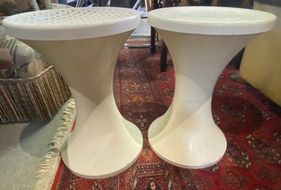 deux tabourets blancs posés sur un tapis dans un salon