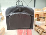 a black backpack hanging from a hanger in a warehouse