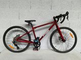un vélo rouge appuyé contre un mur blanc