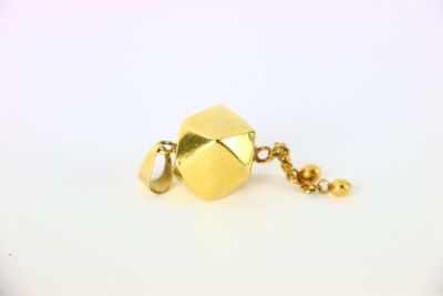 gros plan d'un collier en or sur une surface blanche