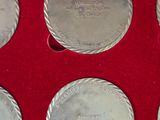 six silver coins in a red box with a red background