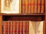 many old books on a wooden shelf in a room