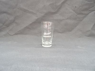 a shot glass sitting on a table with a gray background