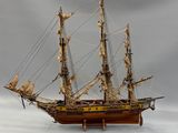 a wooden model of a sailing ship on a table