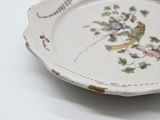 a white plate with a bird on it on a table