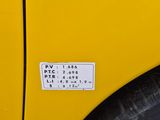 a close up of a yellow car with a sticker on it