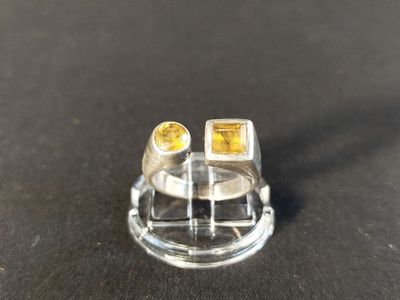 a close up of a ring with two yellow stones on it
