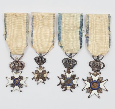 un ensemble composé de quatre médailles et d'une croix sur fond blanc