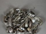 a pile of silver spoons and spoons on a table