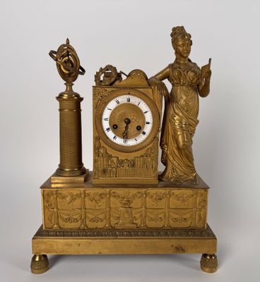a gold clock with a statue on top of it
