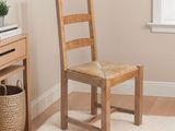 a wooden chair sitting in front of a desk with a basket on top of it