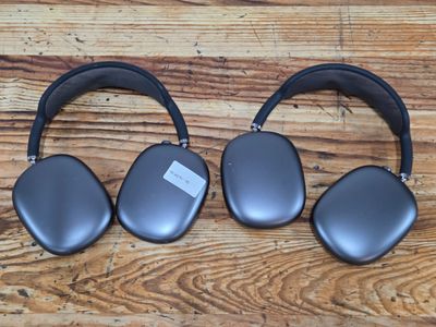 two black headphones sitting on top of a wooden table