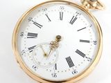 a gold pocket watch with roman numerals on the face