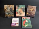 several books are sitting on a table with a black background