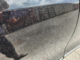 a reflection of a man walking on the side of a car
