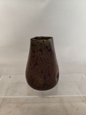 a brown vase sitting on a clear shelf on a table