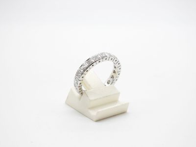 une bague en or blanc et diamants posée sur un socle en marbre