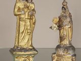 trois figurines représentant Jésus et Marie posées sur une table en verre