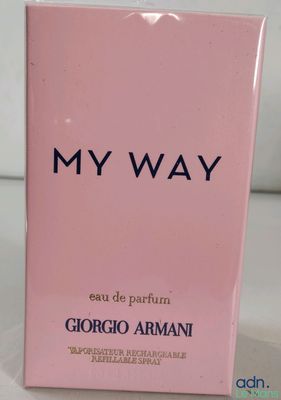 un coffret de parfum rose posé sur une table blanche