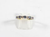 gros plan d'une bague en or avec des saphirs bleus