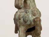 statue of a horse on a wooden table with a white wall in the background
