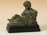 statue en bronze représentant un garçon avec un chien sur les genoux