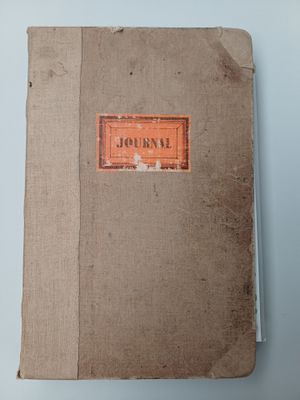 an old book sitting on top of a table next to a blue wall