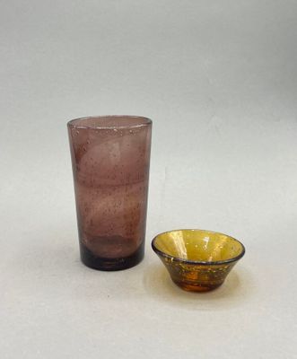 a glass and a bowl sitting on a table