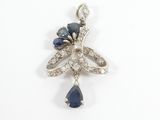 a close up of a diamond and sapphire pendant on a white background