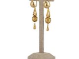 a close up of a pair of earrings on a stand