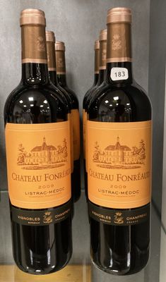 trois bouteilles de vin posées sur une étagère dans un magasin
