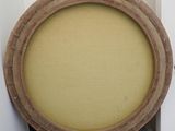 a round wooden frame with a yellow cushion on top of it