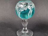 a glass with a flower inside of it on a table