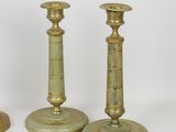 three brass candlesticks are sitting on a white surface