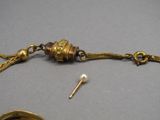 un bracelet en or muni d'une chaîne et d'une broche
