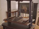 a wooden bed in a room with a painting on the wall