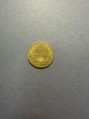 gros plan d'une pièce d'or sur une surface grise