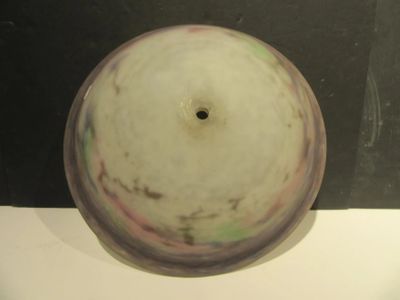 a white vase sitting on a table with a black wall in the background