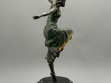 statue d'une femme en robe verte posée sur un socle noir