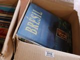 a box full of books sitting on the floor next to a pile of books