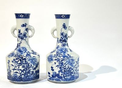 paire de vases bleus et blancs posés sur une surface blanche
