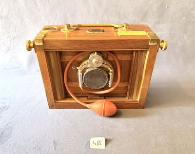une petite boîte en bois avec une balle posée par terre