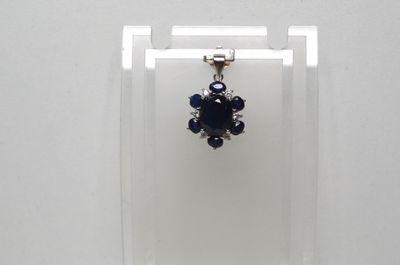 des boucles d'oreilles présentées dans une vitrine posée sur une surface blanche, avec un fond blanc